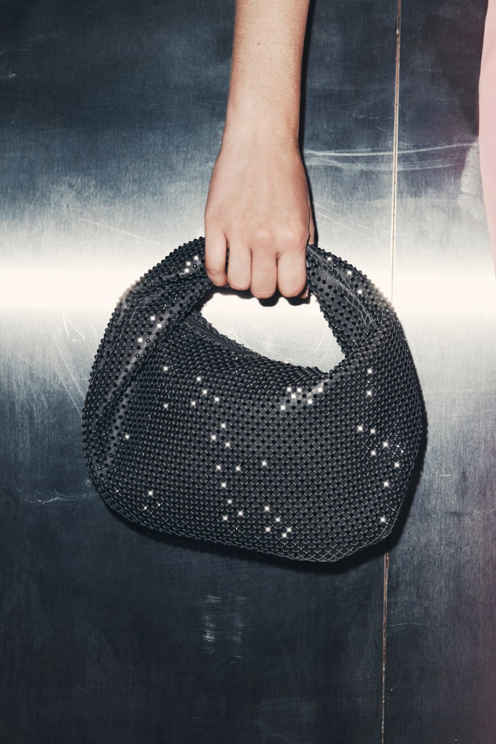 Woman holding the charcoal romy mini jewel bag