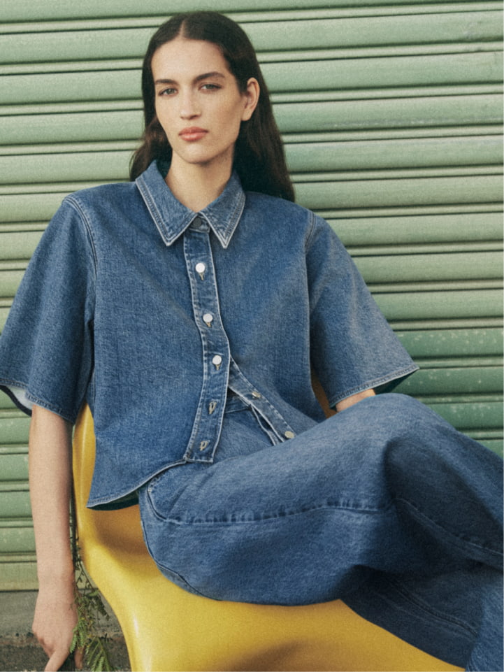 Woman wearing the indigo denim short sleeve shirt and indigo denim slouch jean