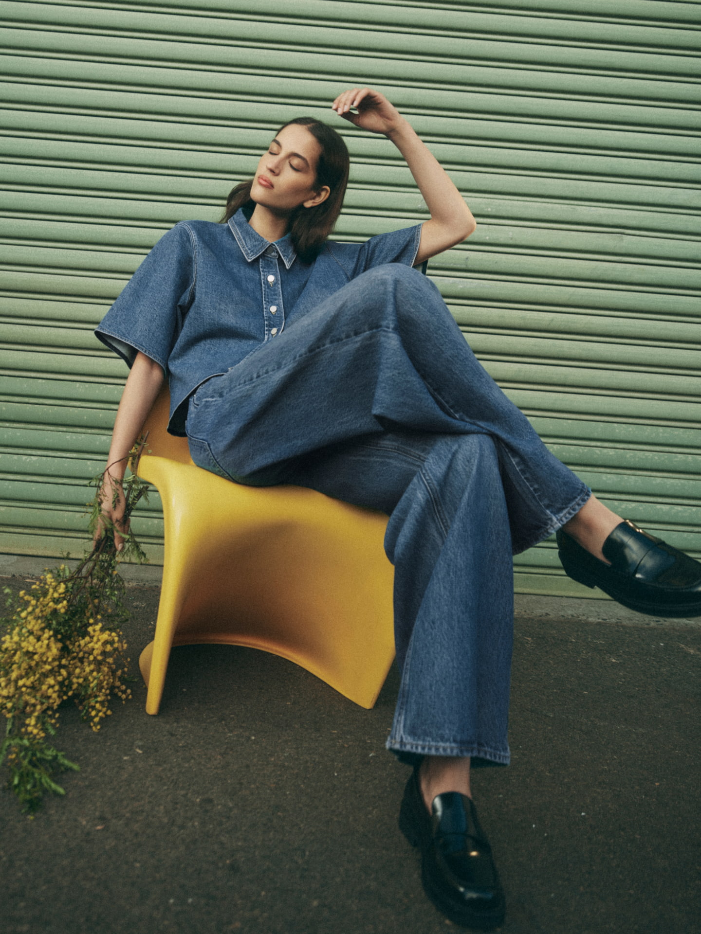 Woman wearing the indigo denim short sleeve shirt, indigo denim slouch jean and black dakota loafers