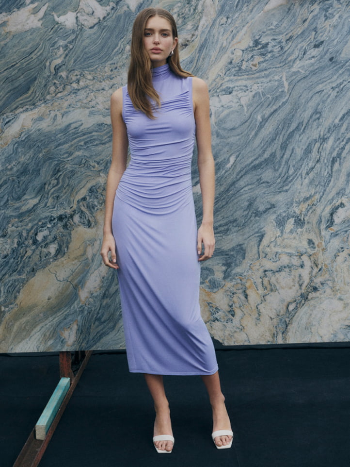 Woman in lilac high neck gather dress and off white grace mule